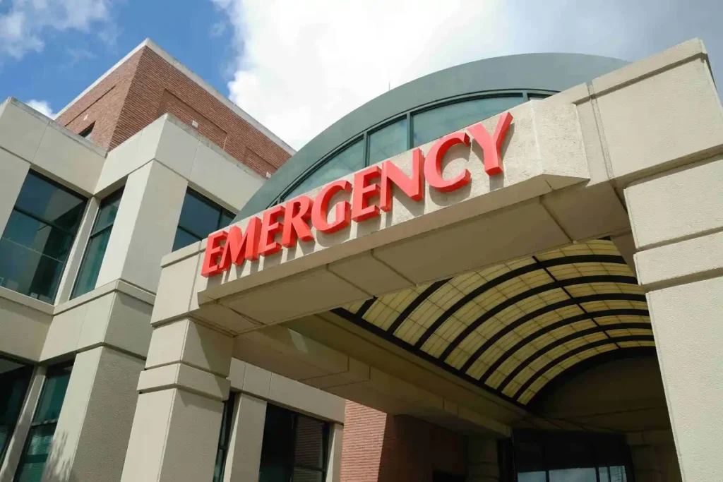 exterior entrance of hospital emergency department with red sign