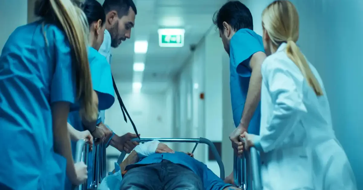 medical team rushing injured patient on stretcher through hospital corridor